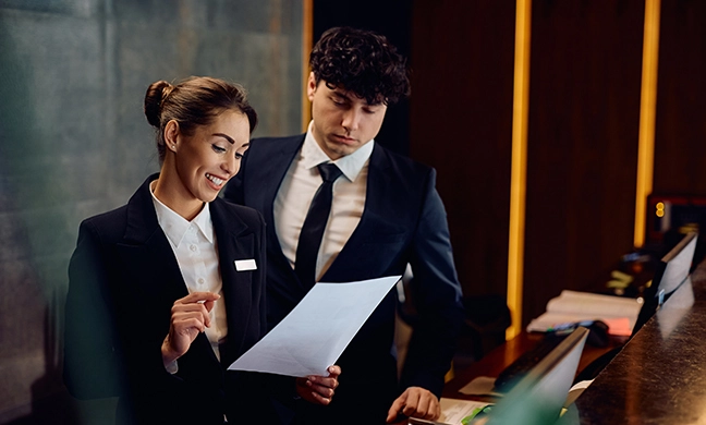 two people reviewing a document in an auditorium