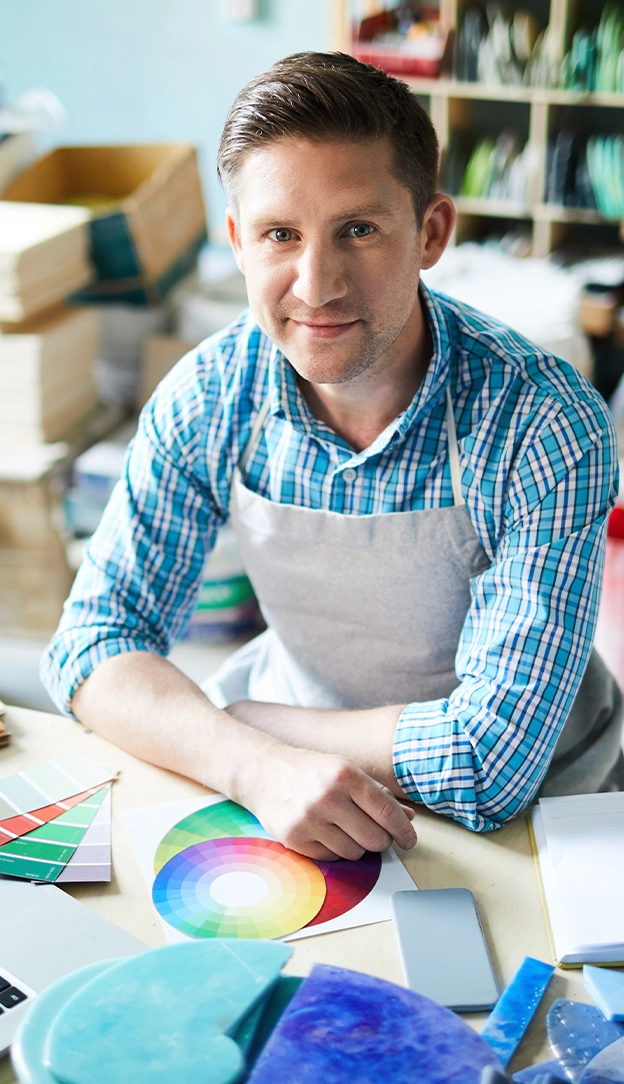 man sitting at his desk full of artistic elements