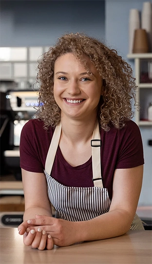 curly-haired woman posing and smiling at the camera